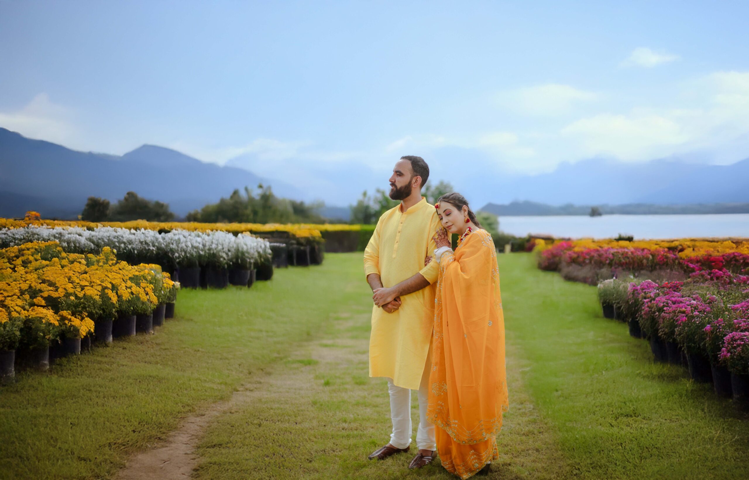 a man and woman standing in a field of flowers